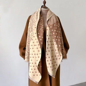 Dettaglio della sciarpa retrò a pois e paisley con morbide frange per l'inverno