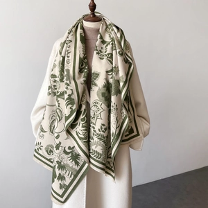 Elegant off-white floral shawl with green botanical print and fringe on a model