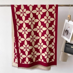 Dettaglio del motivo floreale jacquard bicolore e dei bordi con frange della sciarpa