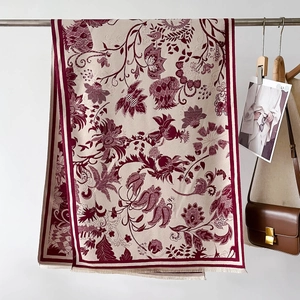 Detail of floral jacquard shawl with wine red botanical patterns and fringe edges