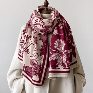 Close-up of vintage floral pattern and soft fringe on elegant burgundy shawl