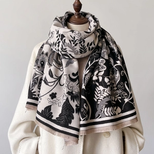 Elegant vintage floral print shawl with fringe trim displayed on a mannequin over a coat