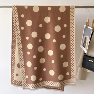 Detail of coffee brown polka dot scarf featuring frayed edges and soft texture