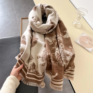 Detail of soft brown and beige cashmere scarf featuring vintage floral and bird patterns