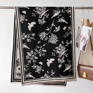 Close-up of black and white floral bird print shawl with detailed fringe texture