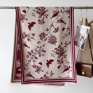 Detail of floral bird print scarf with fringe edges and thick cashmere-like texture
