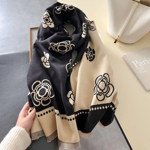 Close-up of thick faux cashmere scarf with camellia pattern and fringe detail