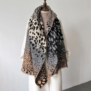 Sciarpa invernale morbida leopardata con frange drappeggiata su un cappotto elegante