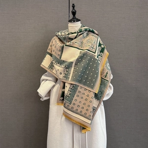 Detail of cashmere-like shawl featuring paisley patterns and contrasting yellow tassels