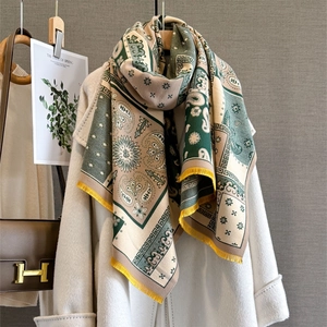 Bohemian paisley cashmere-feel scarf with yellow tassels over a white coat