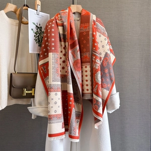 Close-up of bohemian paisley cashmere-like scarf with fringe detail on wool coat
