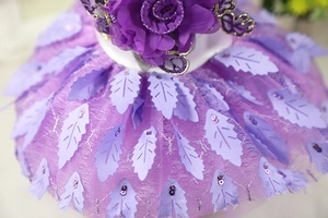 Detail of purple pet wedding dress with mesh fabric, floral accents and shiny leaf sequins