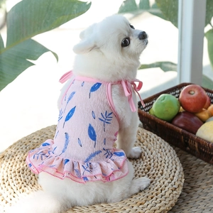 Detalle de vestido rosa para perro con estampado de hojas y tirantes de lazo ajustables
