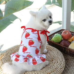 Detalle del chaleco blanco para mascotas con estampados de fresas y lazos rojos