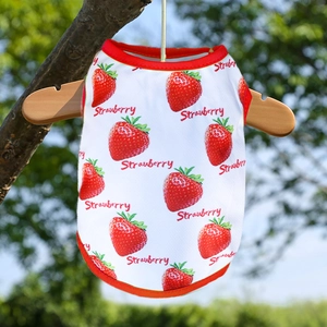 Detalle del chaleco blanco para mascotas con estampado de fresas en percha de madera