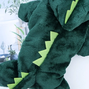 Close-up of green dinosaur pet hoodie showing soft plush fabric and felt spine detail