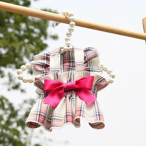 Détail d'une robe à carreaux pour animaux avec grand nœud en satin et cintre en perles