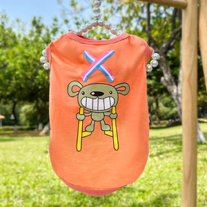 Gilet orange pour animaux avec imprimé ours et ruban, suspendu sur cintre perlé