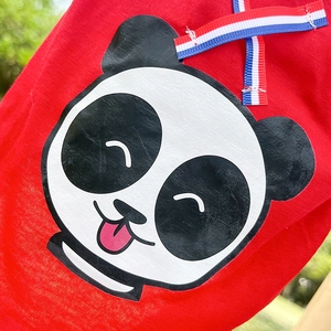 Détail de la veste rouge pour animaux avec motif panda et nœud en ruban tricolore