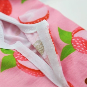 Macro detail of strawberry print pet recovery suit with white Velcro closure