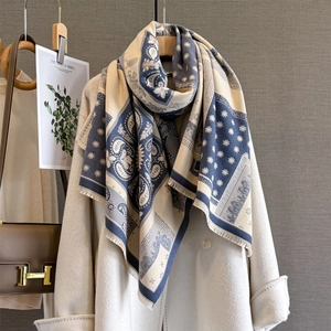 Detail of winter paisley pashmina scarf with fringe on a beige coat display