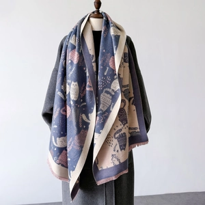 Detail of soft reversible cashmere-feel shawl featuring cartoon cat patterns and fine tassels