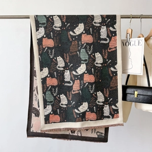 Detail of soft double-sided cashmere scarf with colorful cartoon cat patterns and fringe