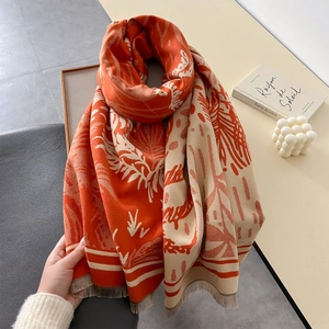 Dettaglio dello scialle simile a cashmere con foglie tropicali e frange beige