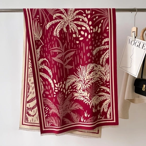 Dettaglio della sciarpa jacquard bordeaux con motivi a foglia di palma e frange fini