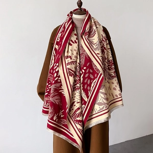 Dettaglio pashmina jacquard rossa e crema con motivi a foglia e bordi con frange