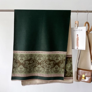 Close-up of thick cashmere-like shawl with green paisley patterns and fringe details