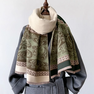 Close-up of green Paisley cashmere scarf with fringed edges on a mannequin