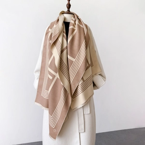 Detailansicht eines geometrischen Schals in Camel und Beige mit feinen Fransenkanten