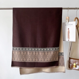Detail of dual-sided scarf with geometric jacquard pattern and tassel fringe trim