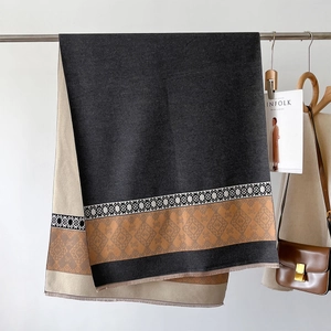 Detail of soft winter shawl with geometric jacquard patterns and delicate fringe edges