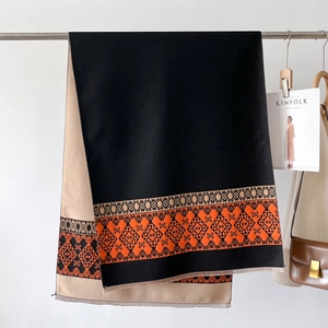 Detail of double-sided cashmere scarf with geometric patterns and short fringe