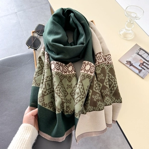 Detailed view of winter thick scarf with dark green geometric jacquard and fringe edges