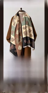 Detailed texture of thick winter scarf with ginkgo leaf pattern and fringe edges