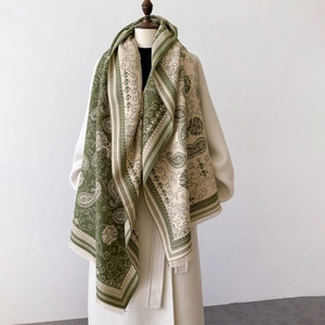 Detailansicht eines grün-beigen Schals mit Paisleymuster und dekorativen langen Fransen