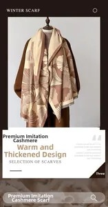 Detailed close-up of thick cashmere-like scarf with warm beige ginkgo leaf pattern and tassels