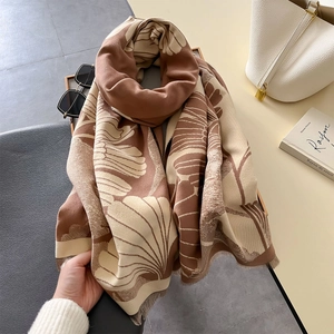 Detailed texture of thick brown and beige scarf with ginkgo leaves and soft tassels