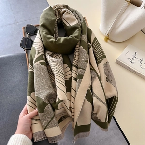 Detail of olive green and beige scarf with plant leaf print and soft grey tassels