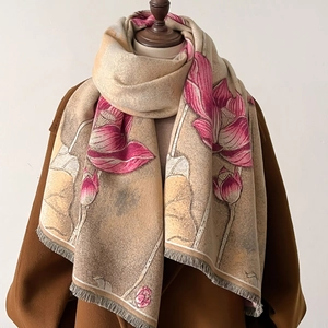Gros plan sur l'imprimé lotus et les franges d'un châle pashmina d'hiver beige