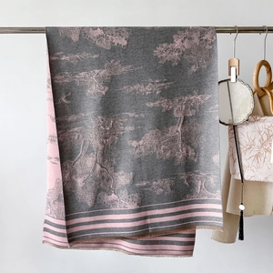 Detail of gray and pink wool-like scarf showing nature pattern and fringe edge