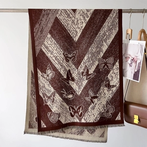 Detail of soft brown and beige butterfly pattern scarf with fringe and knit texture