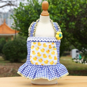 Detail of blue plaid pet dress featuring a yellow duck pocket and white lace trim