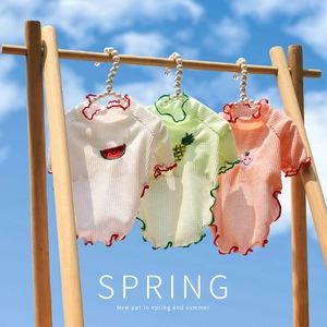 Détail de gilets pour animaux en tissu gaufré avec broderies de fruits et ciel bleu