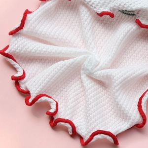 Gros plan sur tissu gaufré blanc avec bordure rouge ondulée pour habits d'animaux