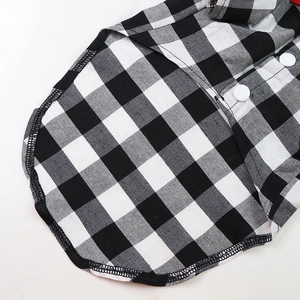 Detail of plaid pet shirt with red bowtie, white buttons and fine stitching texture