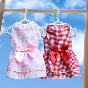 Pink and red plaid pet wedding dresses with satin bows on pearl hangers under blue sky